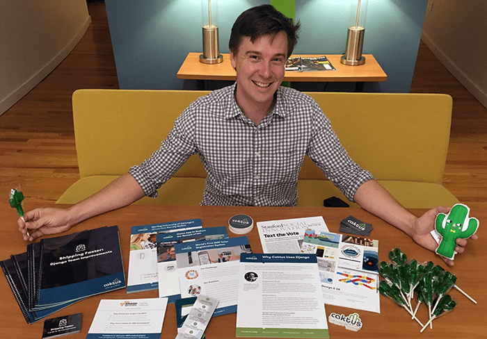 Account Manager Tim Scales with a table full of various Caktus promotional materials.