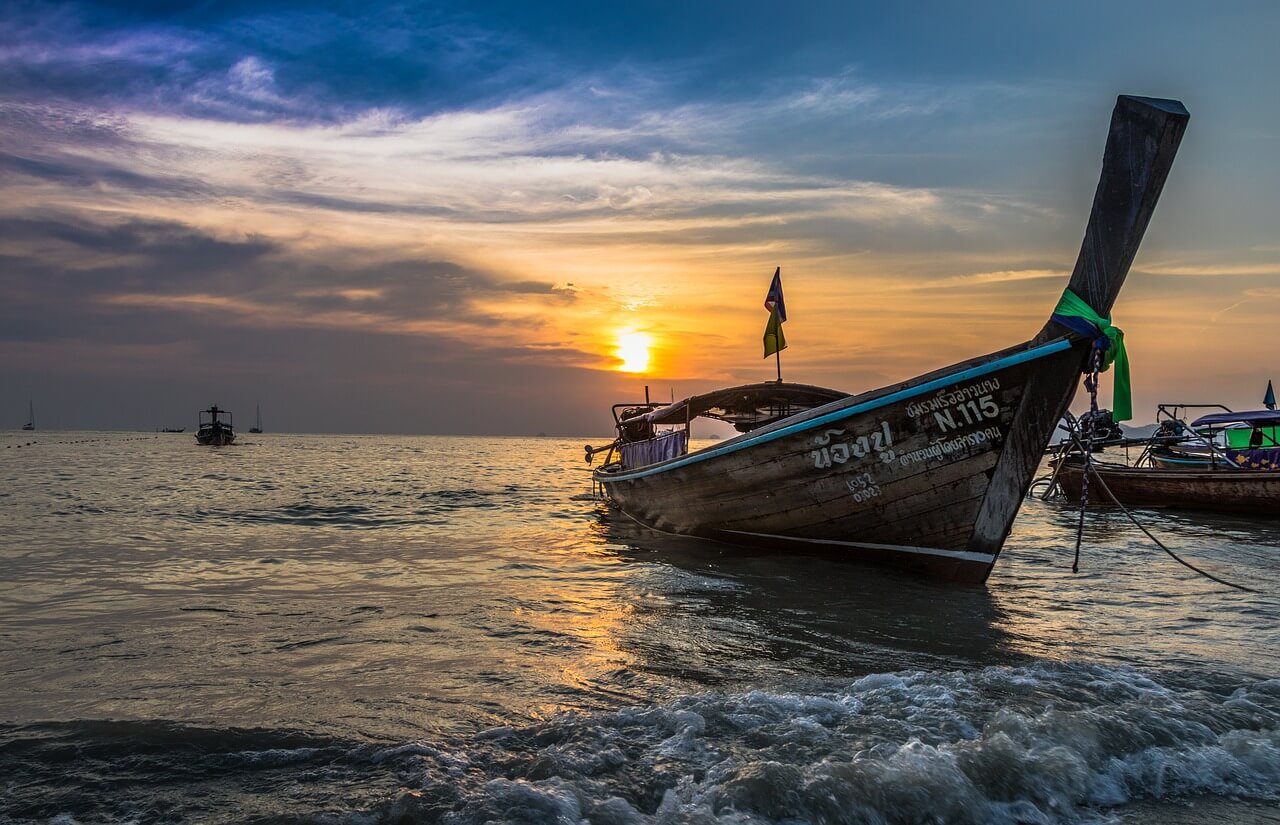 A ship at the shore at sunset.