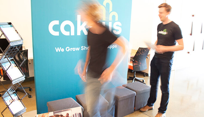 Two team members busily preparing materials for the Caktus booth