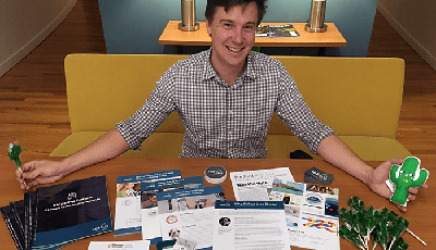 Account Manager Tim Scales with a table full of various Caktus promotional materials.